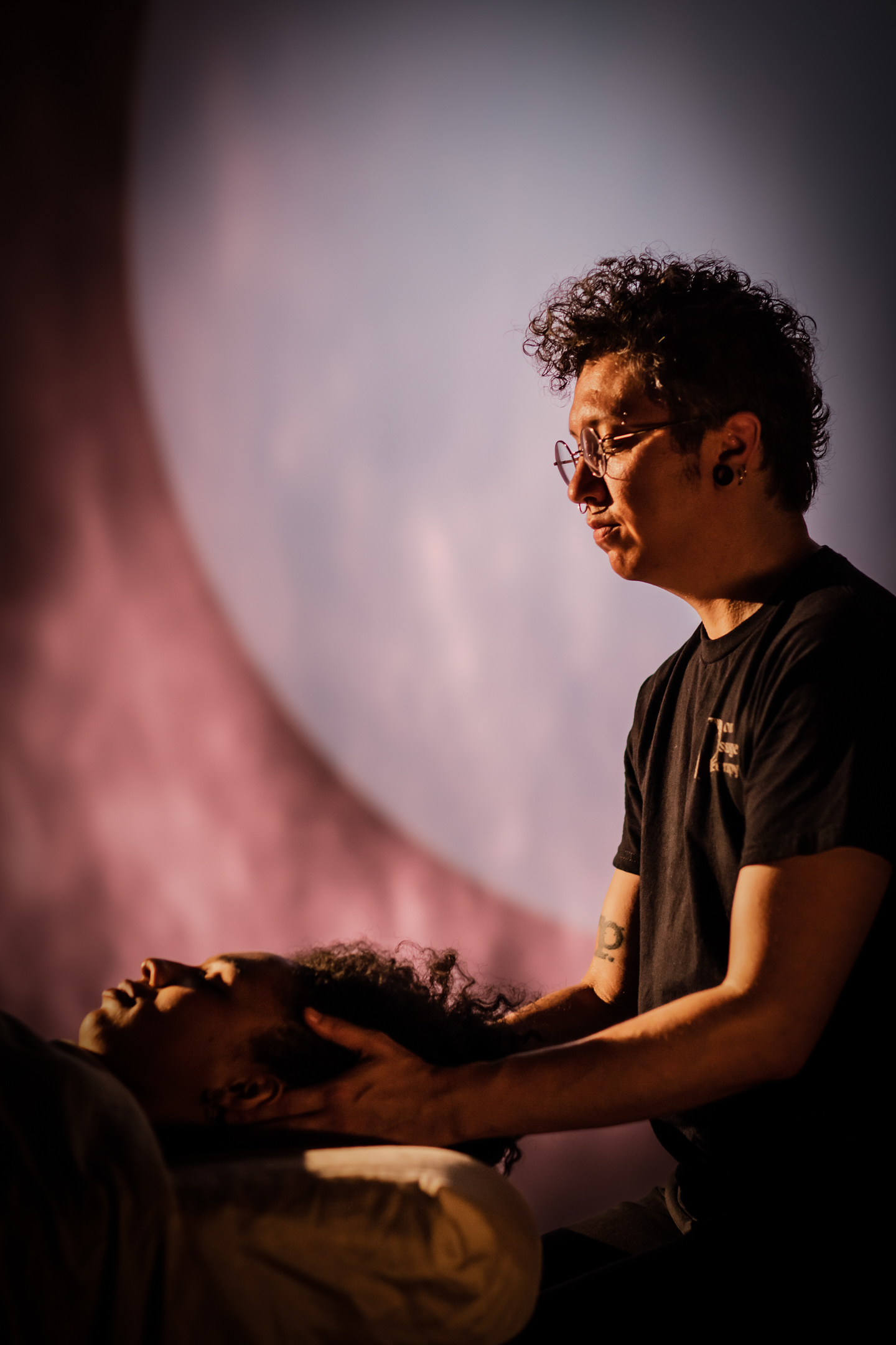 Fox holding client's head during a massage and energy work session with a moon in the background.