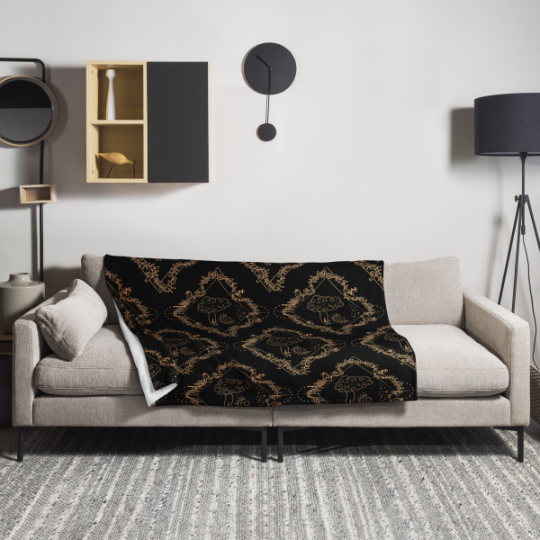 Black throw blanket draped across a gray mod sofa in a minimalist living room with lamp, shelving, and black wall clock.